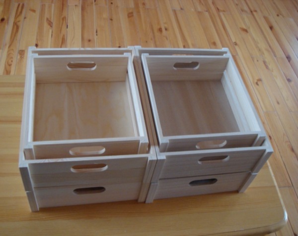 Stacking unfinished custom wooden crates with hand cutouts, available in bulk for storage, retail display, and product organization.